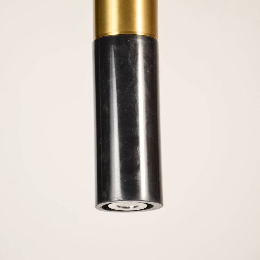 Black marble and metal long cylinder pendant light shown in close up view with light off for sophisticated modern décor.