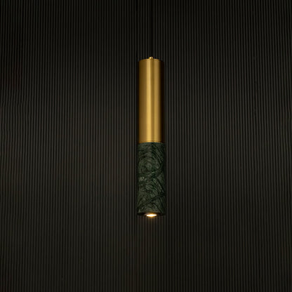 Green marble and metal cylinder pendant light hanging against dark textured wall with light off for stylish luxury décor.