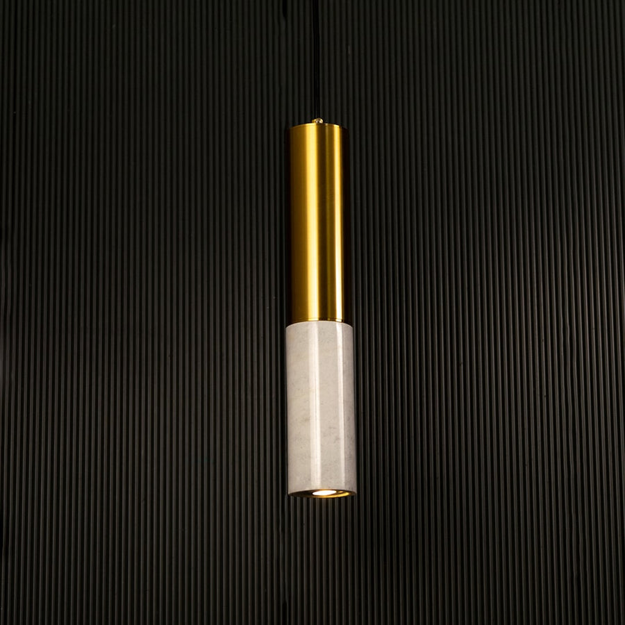 White marble and metal cylinder pendant light hanging against dark textured wall with light off for clean elegant décor.