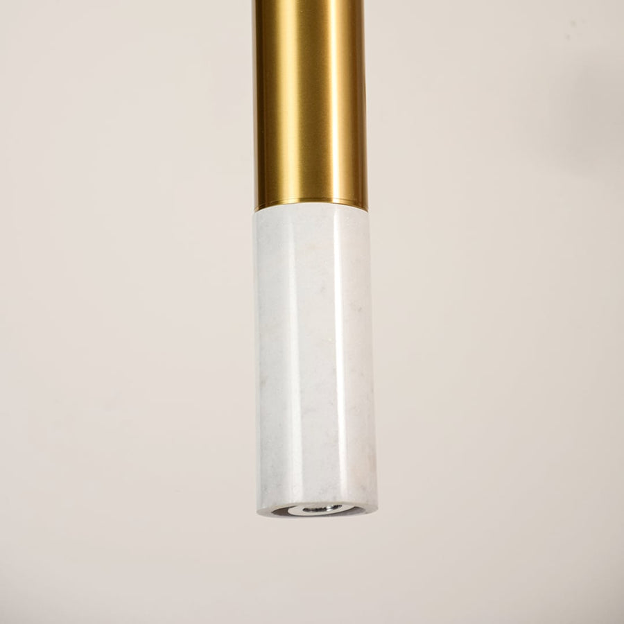 White marble and metal long cylinder pendant light shown in close up view with light off for clean contemporary décor.