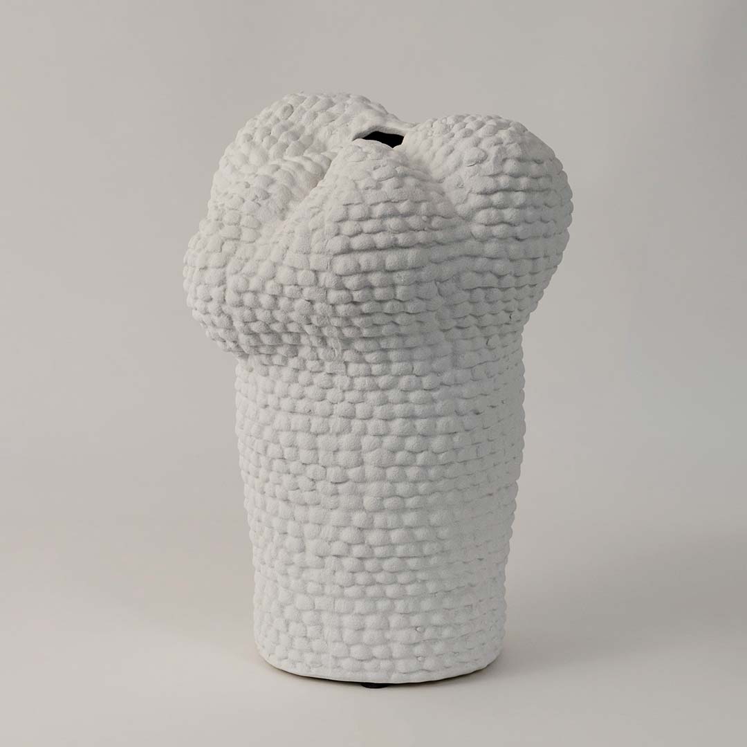 Side view of Pebble textured white ceramic vase displaying its uneven organic form and detailed artisanal surface.