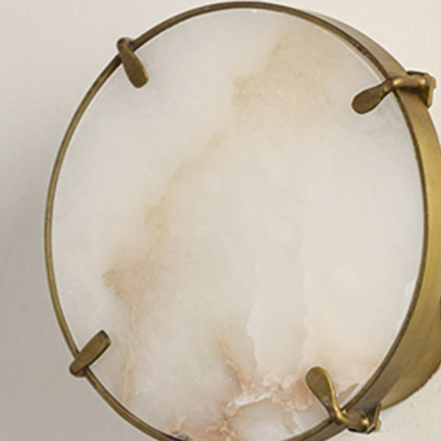 Closeup of white marble and gold metal wall light for premium bedroom and modern decor styling spaces.