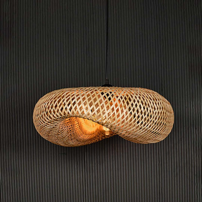 Wide rattan pendant light with woven bamboo shade turned on glowing softly against plain black background.