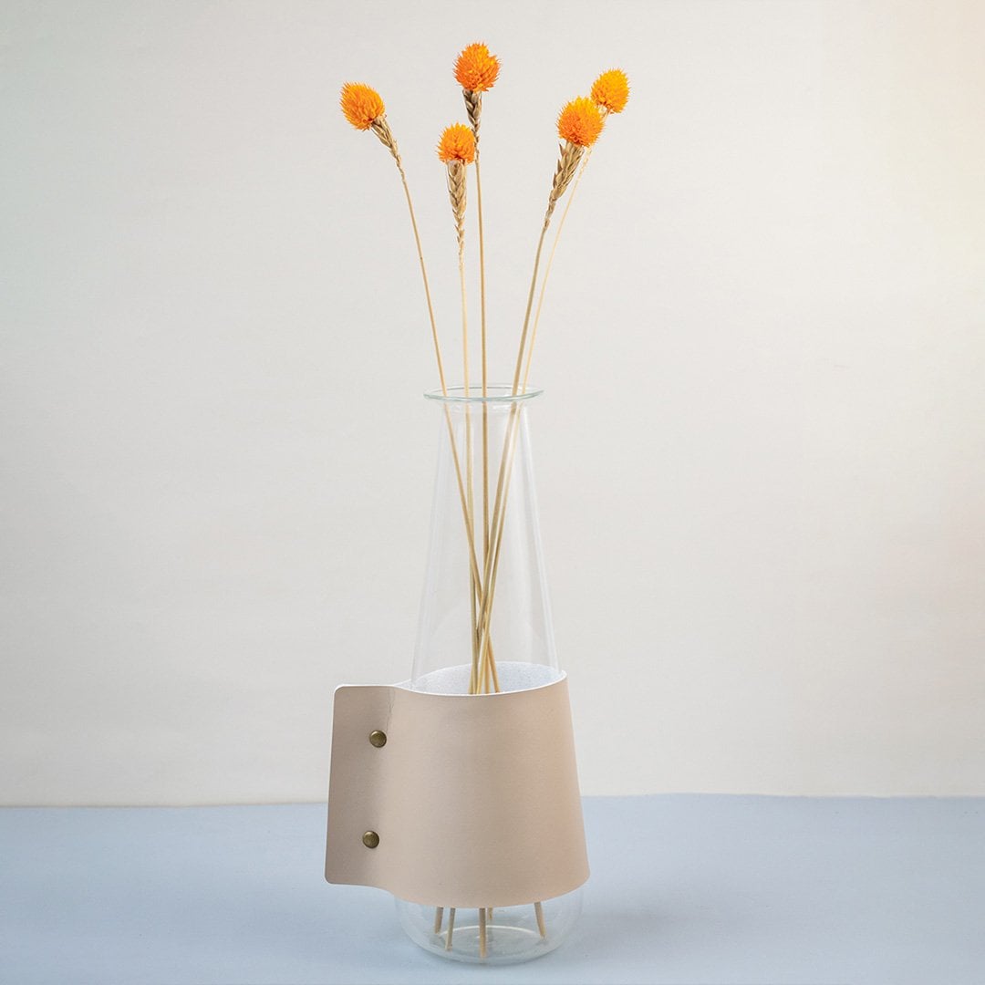 Bright orange dried flower stem styled in a warm modern room adding a bold natural accent to contemporary home decor.