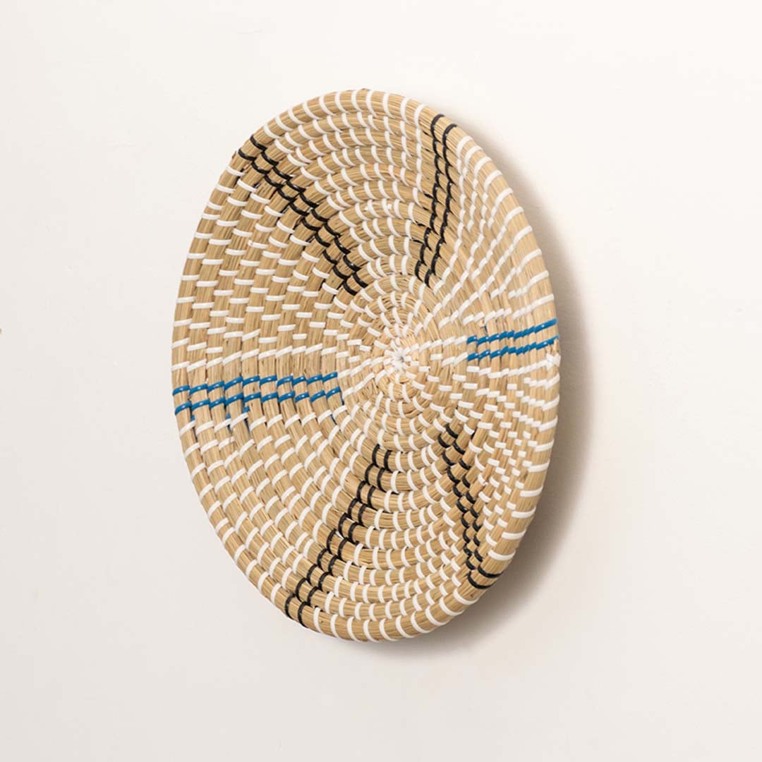 Side view of woven wall basket showing depth curvature and tightly handwoven fibers made from sustainable natural material.