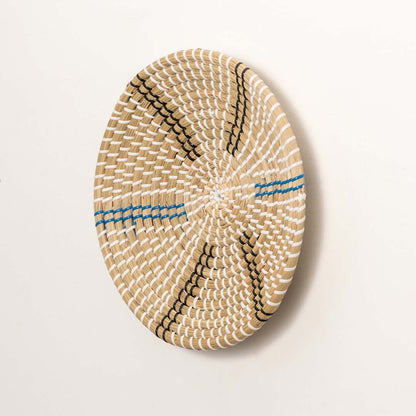 Side view of woven wall basket showing depth curvature and tightly handwoven fibers made from sustainable natural material.
