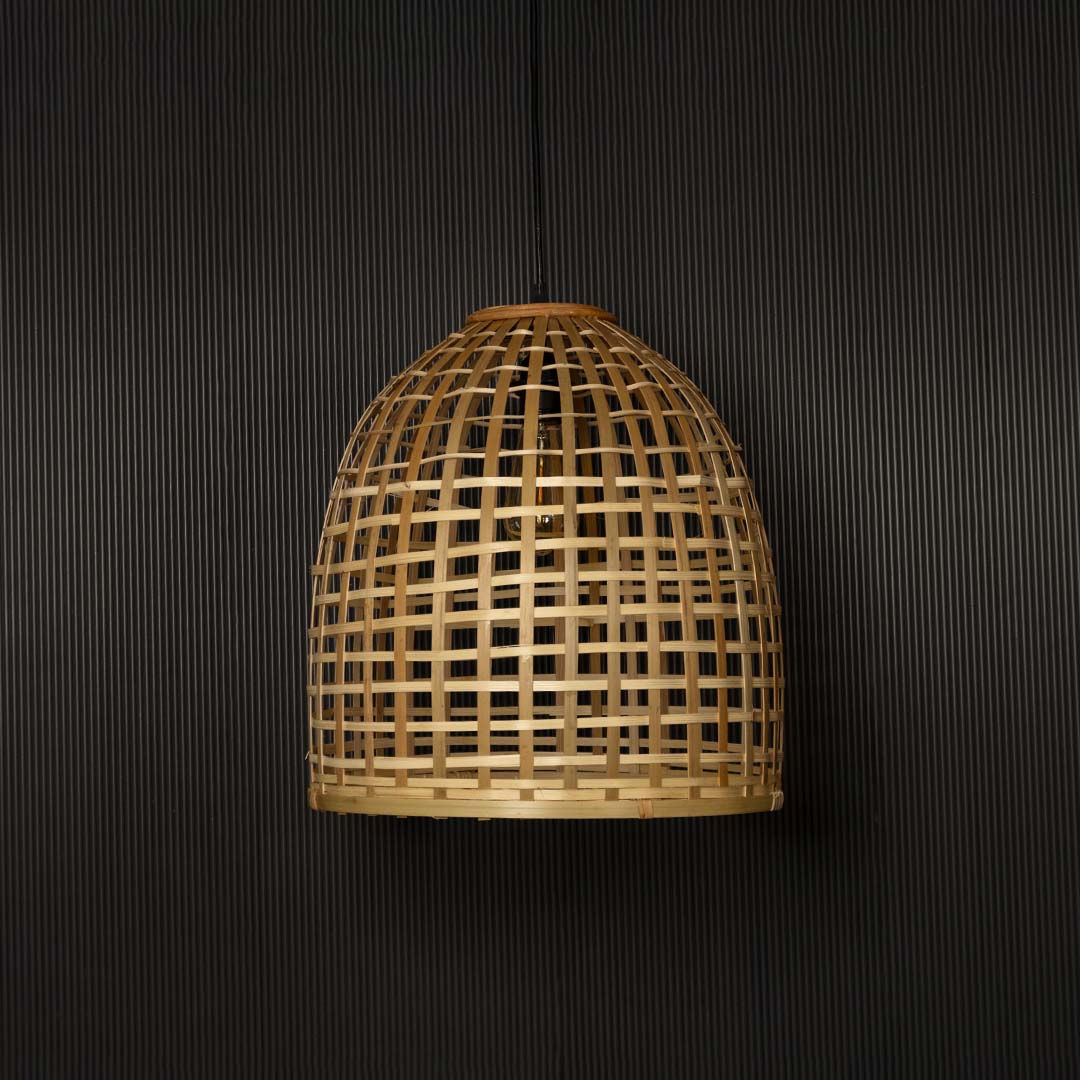 Natural bamboo pendant light illuminated beautifully on black background creating rustic warm home vibe.