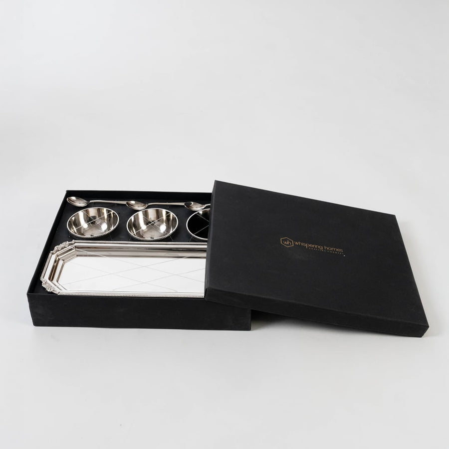Silver condiment set presented in an open black gift box on a white background highlighting the polished bowls spoons and tray in a premium layout.