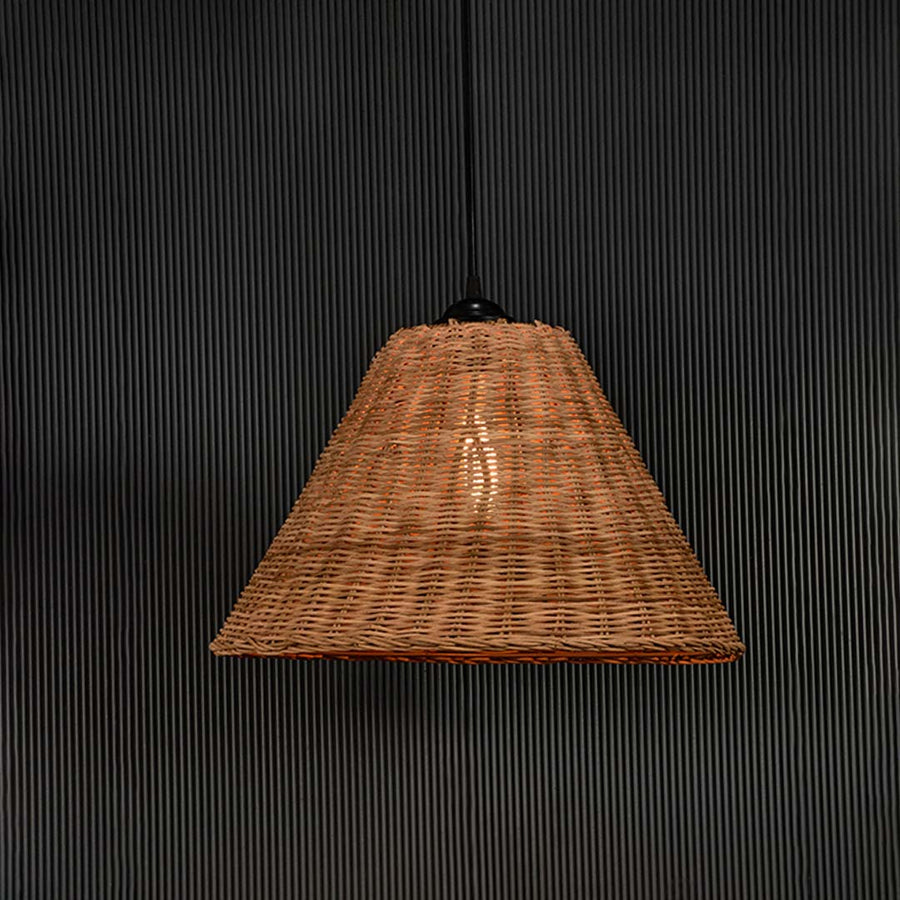 Rattan pendant light glowing warmly on black background emphasizing its natural weave and rustic elegance.