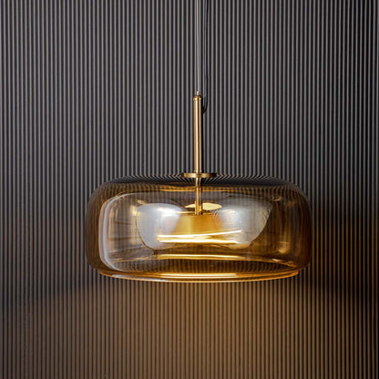 Closeup of amber glass pendant light with brass canopy showcasing premium craftsmanship details.