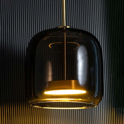Smoked black glass pendant light with brass accents glowing for luxurious interiors.