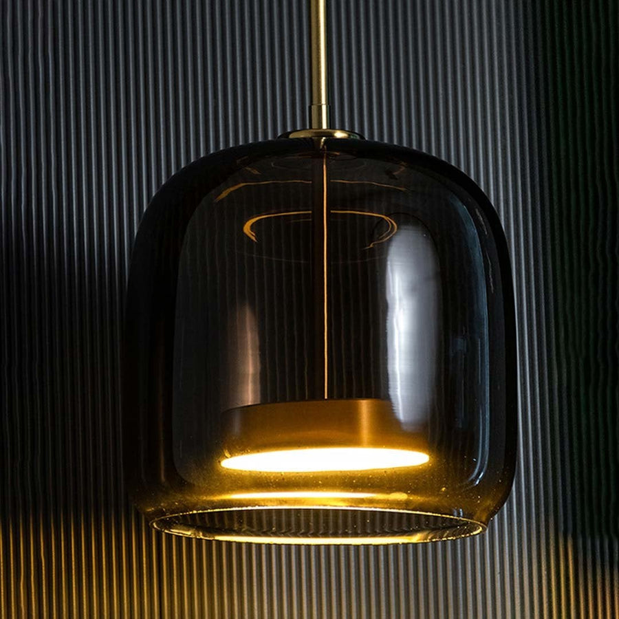 Smoked black glass pendant light with brass accents glowing for luxurious interiors.