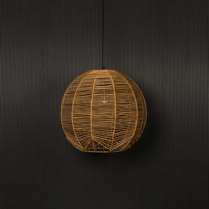 Round rattan pendant light on black background emphasizing its detailed weave and organic form.