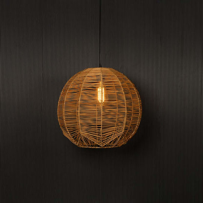Natural rattan pendant light on white background glowing softly for a warm organic aesthetic.