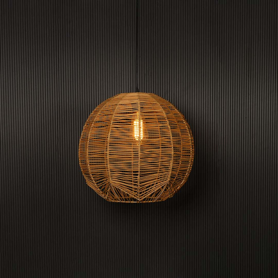 Natural rattan pendant light on white background glowing softly for a warm organic aesthetic.