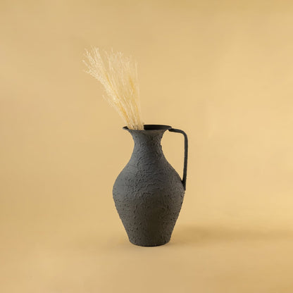 Grey metal tall jug vase decor styled in a warm modern room adding a bold elegant accent to living room tables and corner spaces.
