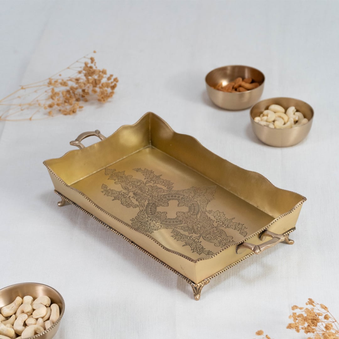 Engraved rectangular brass tray in antique gold finish with wavy edges and dual side handles on white background.