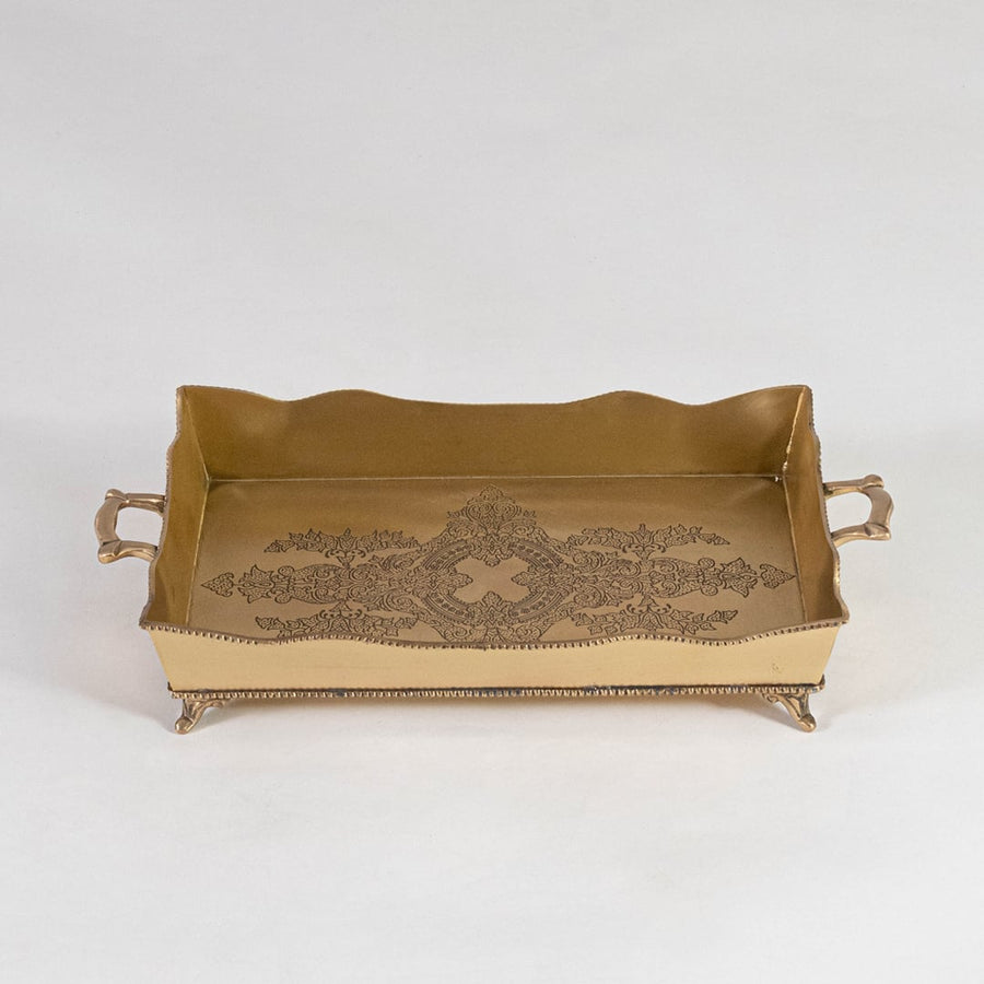 Top view of rectangular brass tray in antique gold with floral engraving and raised handles on white background.