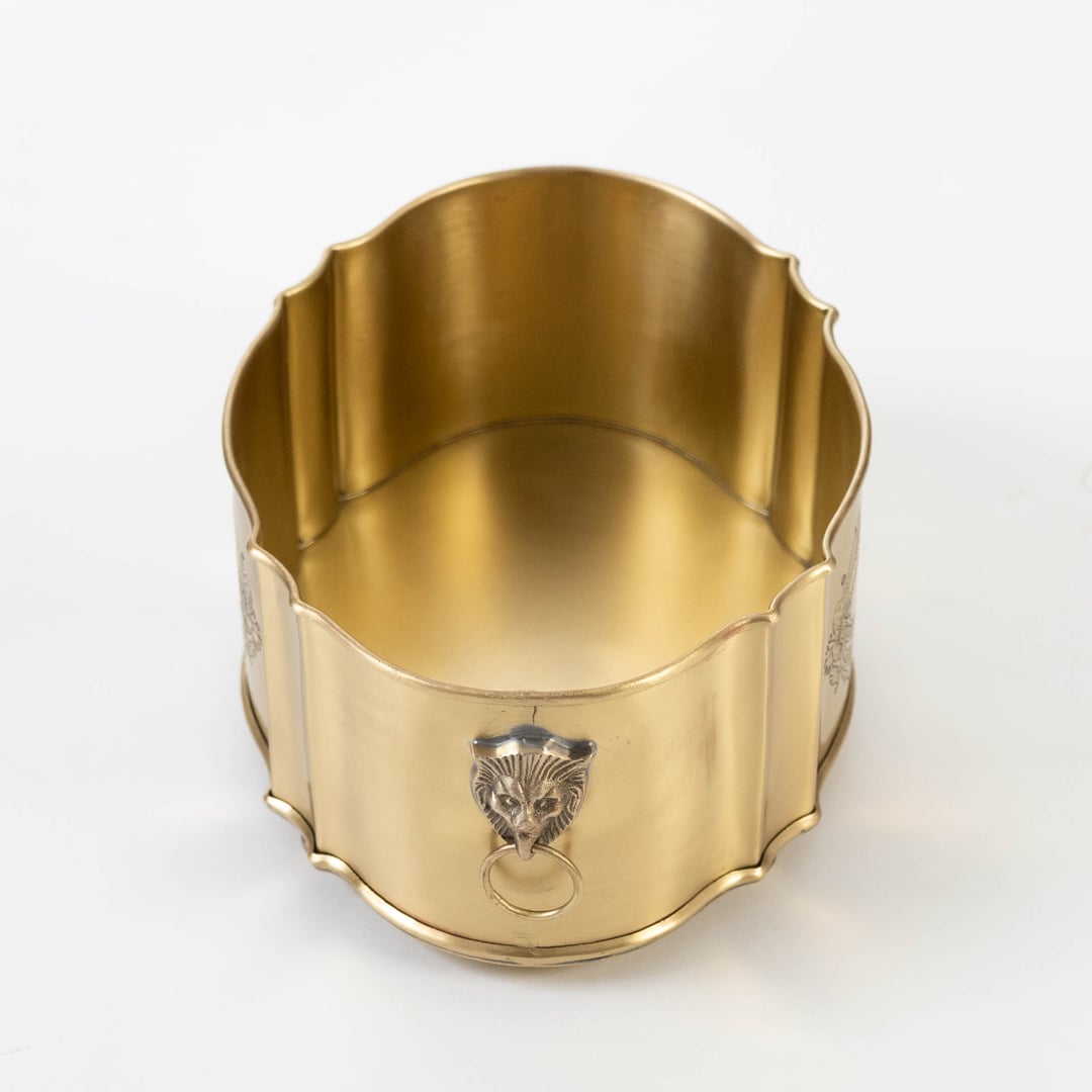 Brass fruit container with smooth finish neatly packed in premium black gift box with gold logo on white surface.
