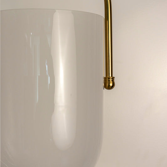 Closeup of frosted glass pendant light with gold metal accents showcasing elegant craftsmanship and style.
