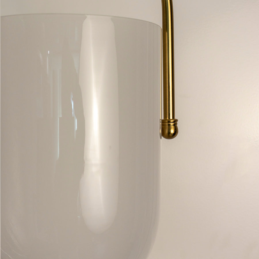 Closeup of frosted glass pendant light with gold metal accents showcasing elegant craftsmanship and style.
