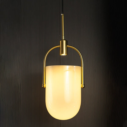 Gold and white pendant light glowing softly through frosted glass shade highlighted against a dark ribbed background.