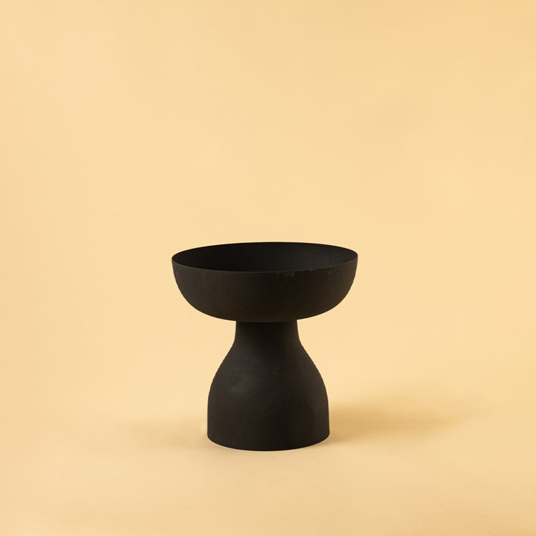 Black pedestal bowl with matte textured finish displayed on a clean white background for bold minimal home decor styling.
