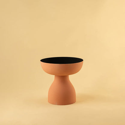 Terracotta orange pedestal bowl with matte finish and black interior displayed on a clean white background for modern decor styling.