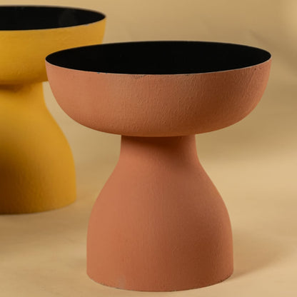 Closeup of yellow pedestal bowl highlighting textured finish and curved shape with deep black interior for modern decor accents.