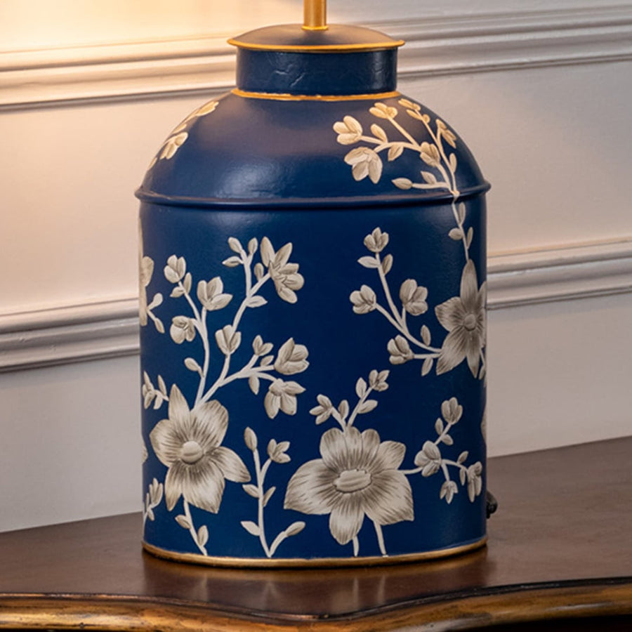 Table lamp closeup featuring deep blue ceramic base with delicate floral design and premium glossy finish.