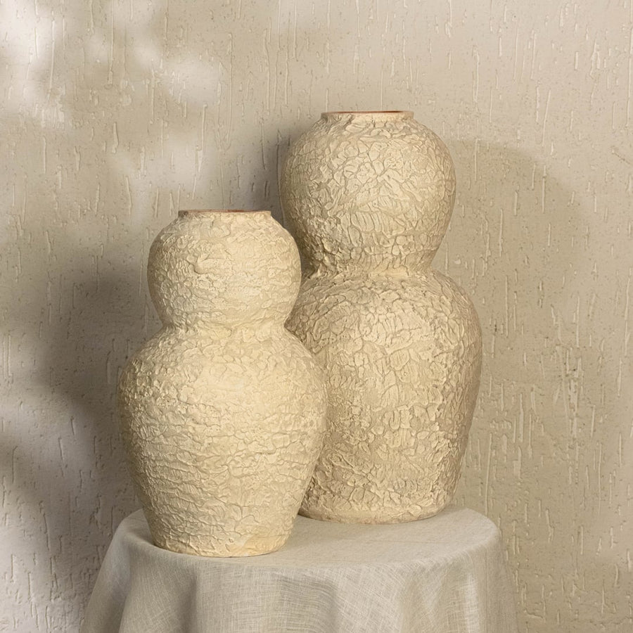 Cream textured decorative vase styled in a warm modern interior adding artistic sculptural decor to living rooms hallways and contemporary spaces.