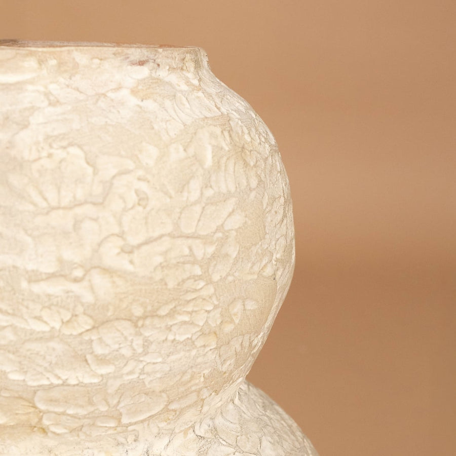 Closeup of cream textured decorative vase showing detailed handcrafted texture and sculpted form ideal for artistic modern home decor.