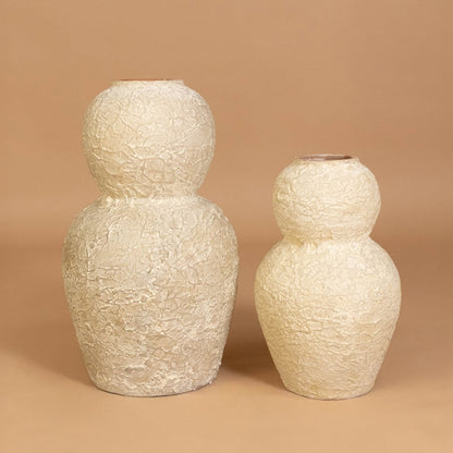 Cream textured decorative vase displayed with coordinating decor items creating a stylish grouped arrangement for contemporary home interiors.