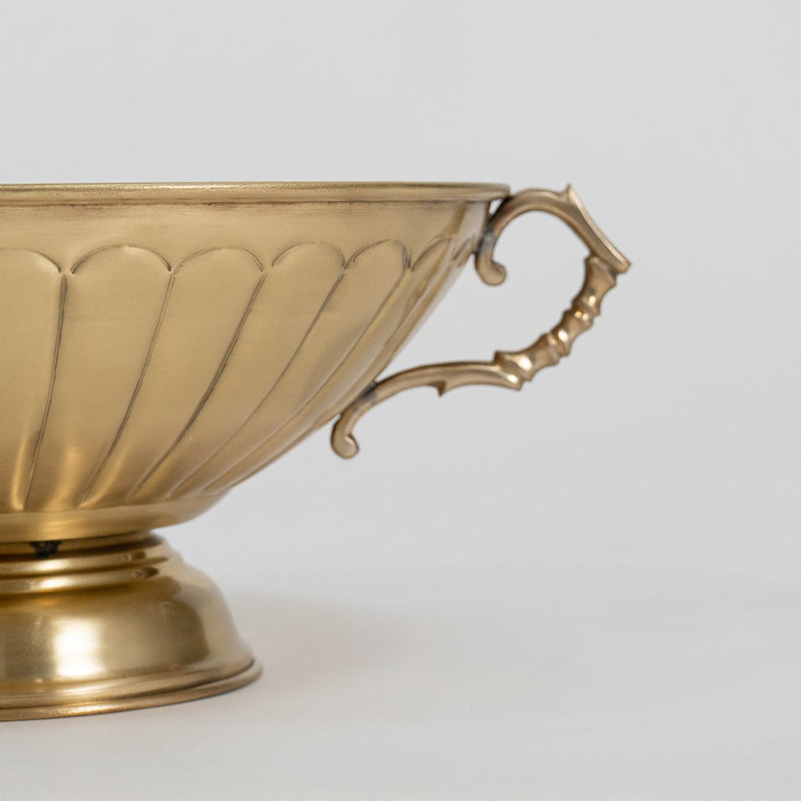 Detailed side view of antique style gold fruit bowl with fluted exterior and elegant vintage style curved handle.