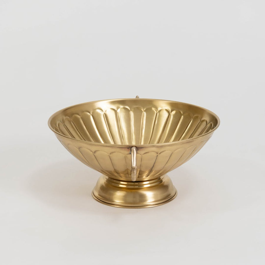 Decorative gold metal fruit bowl with twin ornate handles and fluted texture displayed on plain white background.