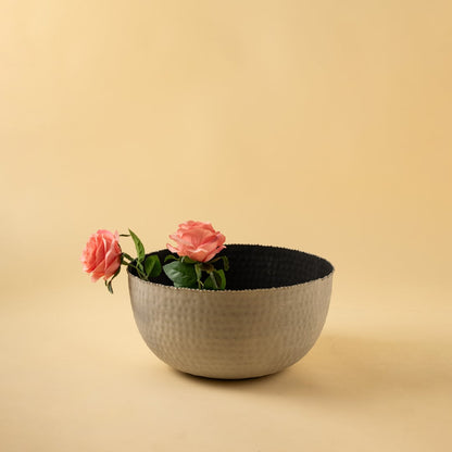Modern hammered metal bowl in soft grey tone displayed in a warm minimal setting adding subtle texture to decor.