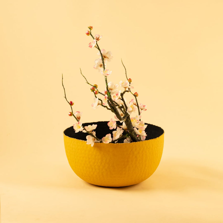 Bold yellow textured metal bowl displayed in a soft neutral scene bringing vibrant modern style to home decor.