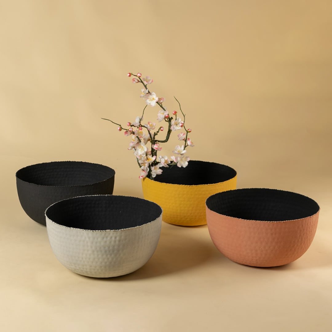 Black hammered metal bowl grouped with decor pieces creating a sleek modern look for living and dining spaces.