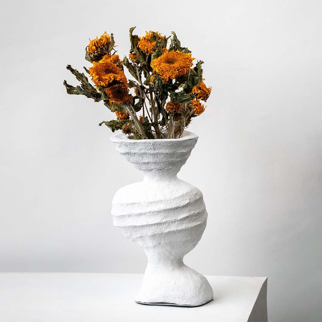 Bright orange dried marigold bunch held in hand adding warm rustic charm to a natural modern home decor setting.