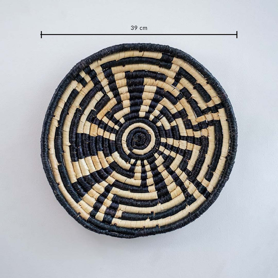 Large handwoven wall basket in natural and black design showing approx 35 cm diameter for statement wall decor use.