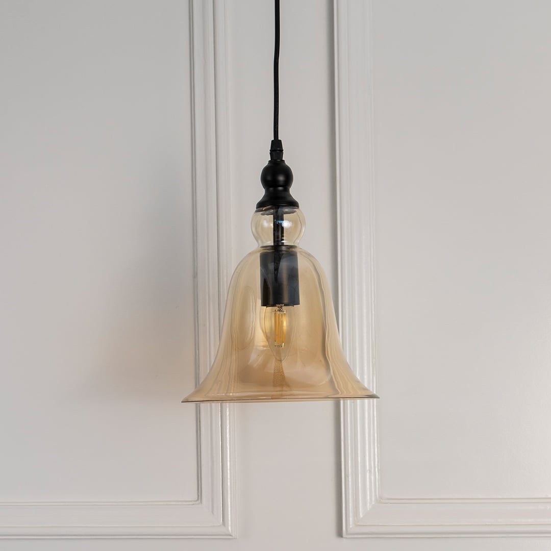 Amber glass pendant light with black metal accents designed for bedrooms and modern living spaces.