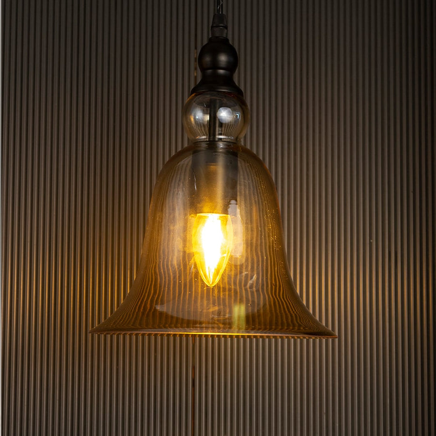 Smoky brown glass pendant light with glowing filament bulb creating cozy lighting for elegant interiors.