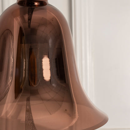 Closeup of smoky brown glass pendant light with black metal fittings highlighting elegant curves and fine craftsmanship.