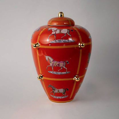 White background image ceramic ginger jar vase with bright orange finish horse motifs golden knobs elegant home decor.