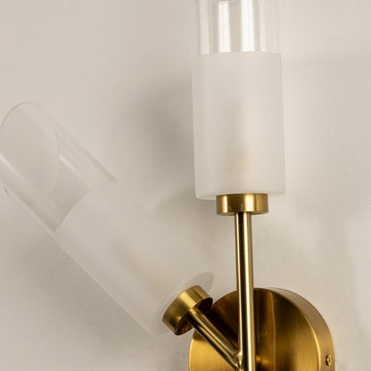 Detailed closeup of brushed gold dual wall light showing soft frosted glass tubes and refined metal finish perfect for modern decorative interiors.