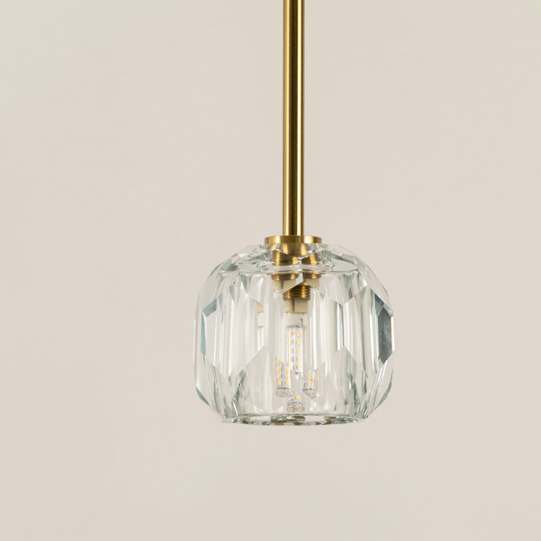 Closeup of clear ribbed glass pendant light with gold hardware showcasing refined craftsmanship.