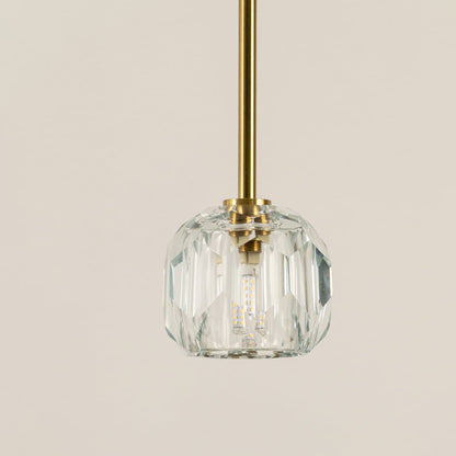 Closeup of clear ribbed glass pendant light with gold hardware showcasing refined craftsmanship.