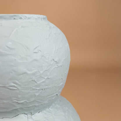 Closeup of textured light blue decorative vase showing detailed handcrafted surface and modern shape perfect for stylish home interior decor.