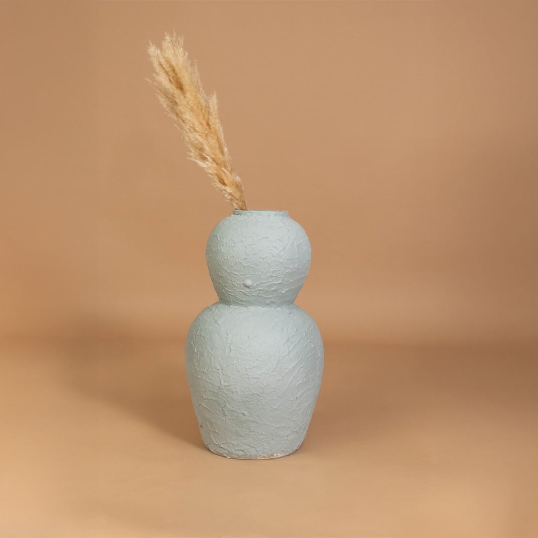 Light blue textured decorative vase styled in a modern home setting adding artistic charm and enhancing living room shelf or console decor.
