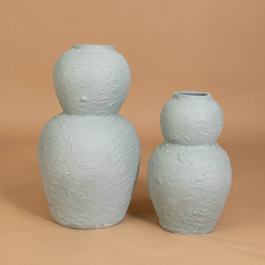 Light blue textured decorative vase displayed with other modern decor items creating a stylish grouped arrangement for contemporary interiors.